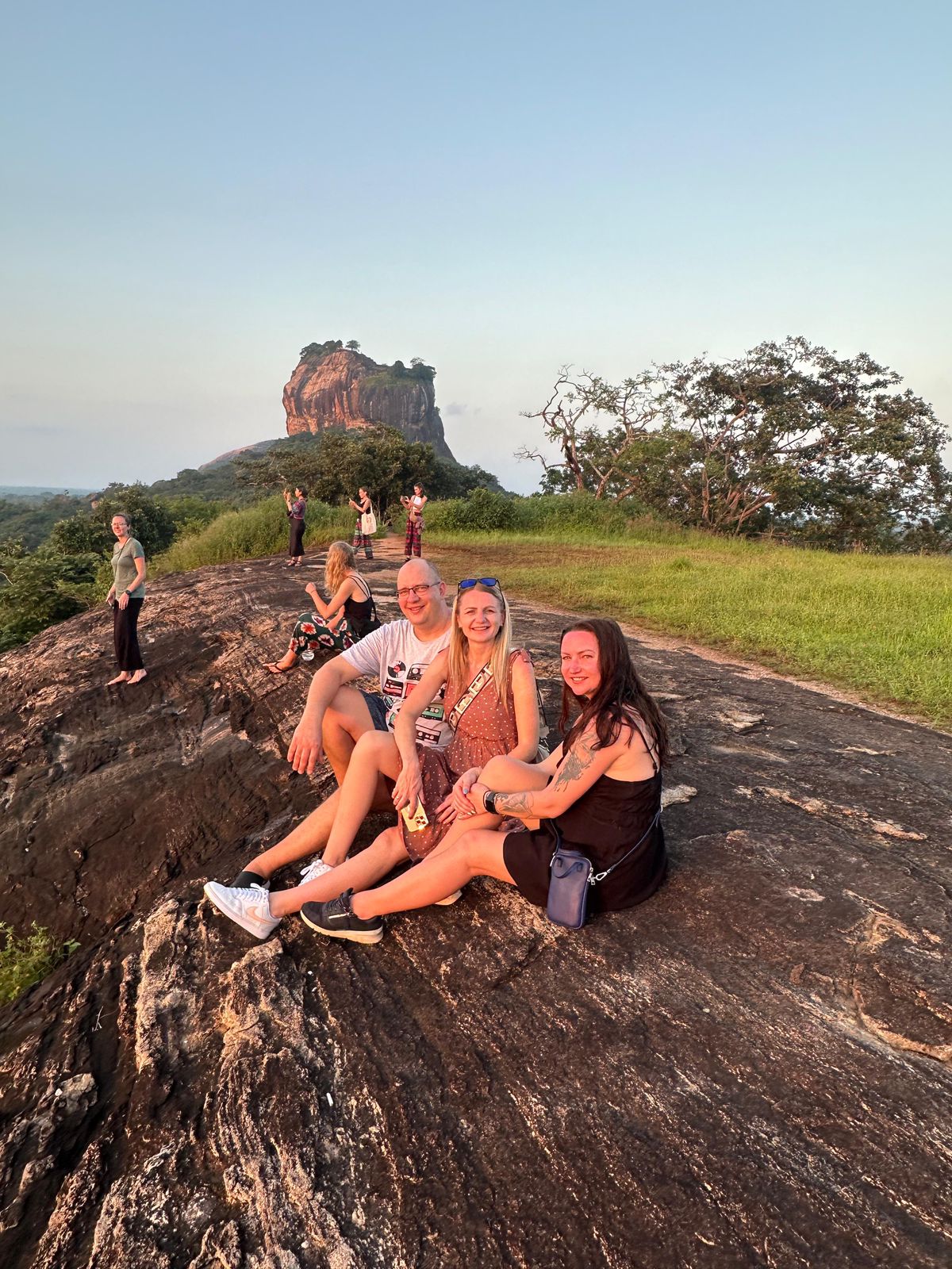 Travellers resting on a rocky viewpoint overlooking Sigiriya