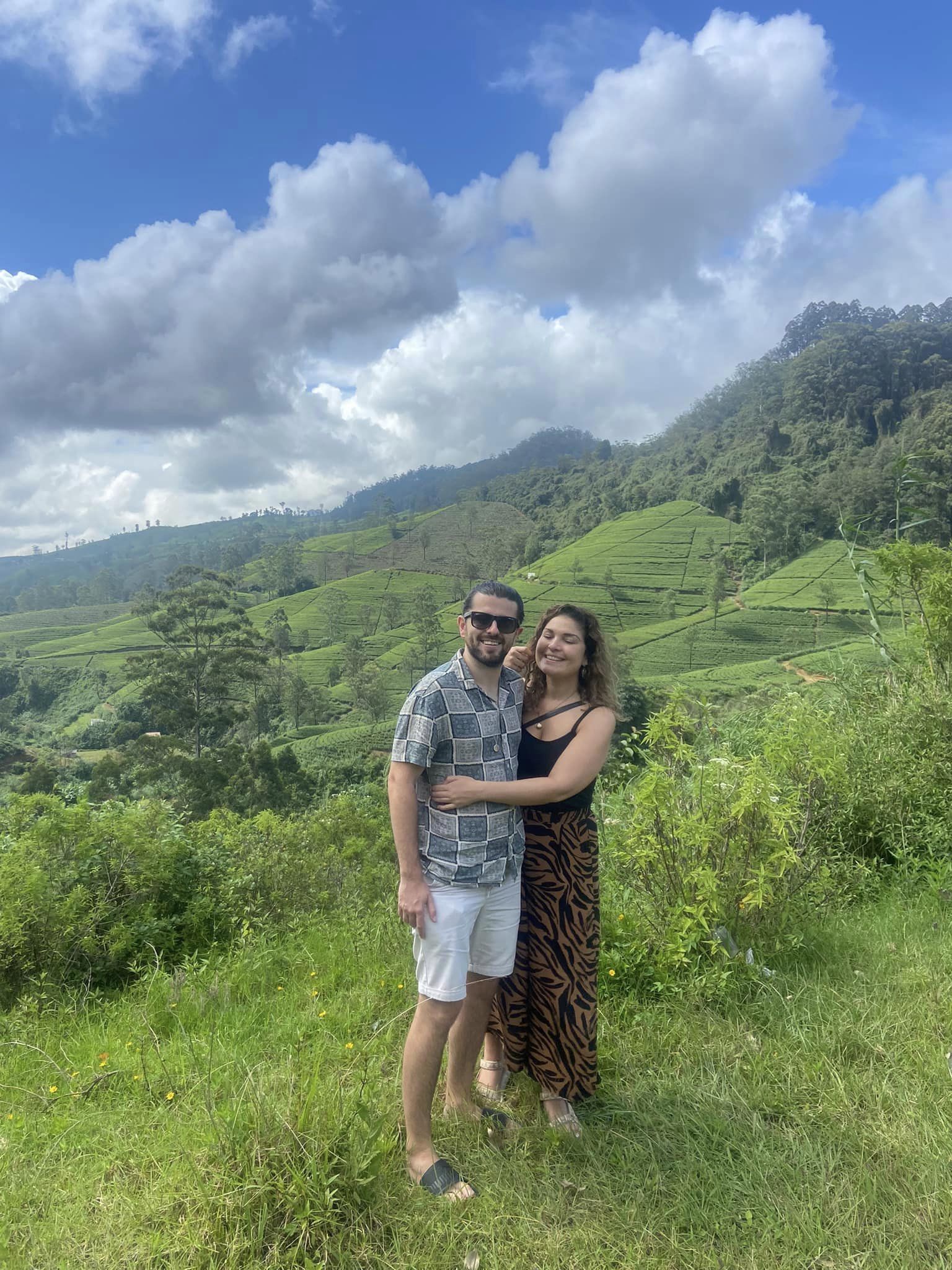 A couple overlooking green hills and tea fields