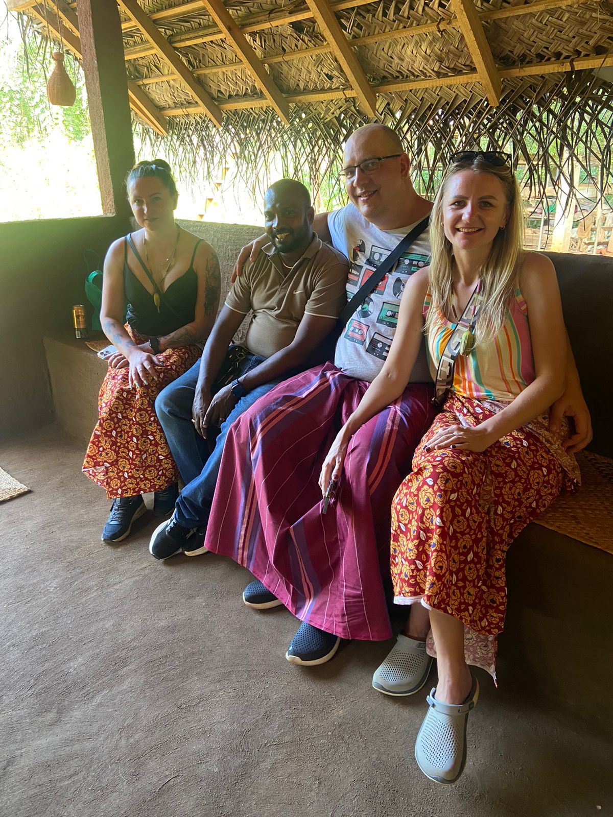 Visitors enjoying a break beneath a thatched roof