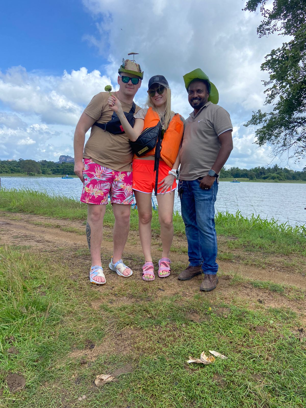 Three travellers standing beside a lake