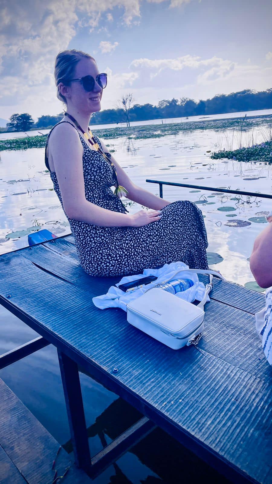 A traveller relaxing on a wooden boat by the water